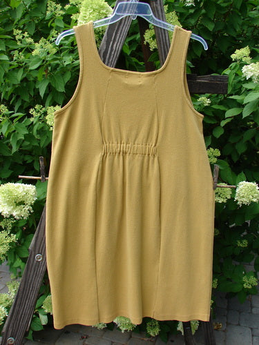 1999 Square Rib Pinafore Jumper Home Gold Size 1: A yellow dress on a clothes rack, made from heavy weight cotton lycra rib. Features include a serious A-line shape, elastic tab rear, and front painted pockets.