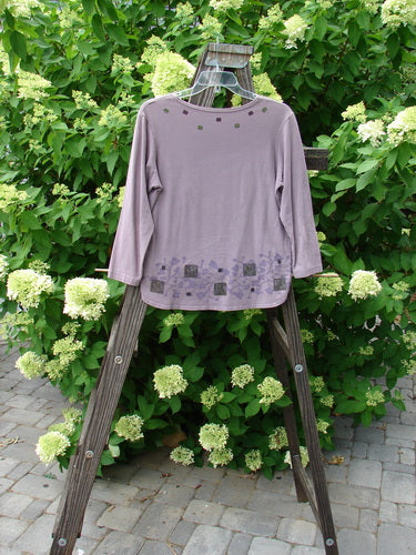 A lavender Barclay Cotton Lycra Round Hem Layering Top with a floral design on it, displayed on a wooden stand.