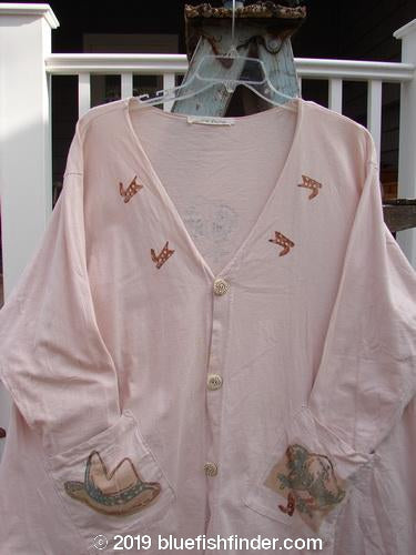 1996 Triangle Cardigan Cowboy Dune OSFA: A pink shirt with a bird design, cowboy hat, and elephant. Features include a deep V neckline, angled front pockets, and a funky paint theme.