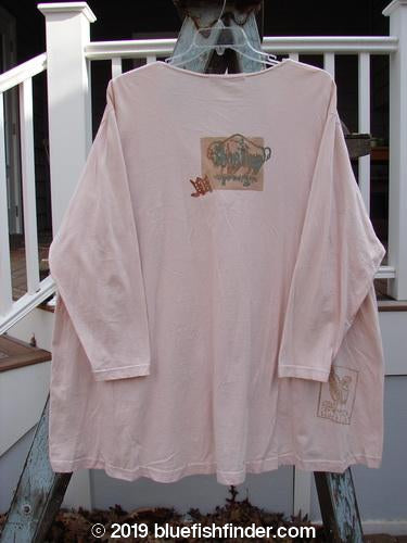 1996 Triangle Cardigan Cowboy Dune OSFA: A pink long-sleeved shirt on a hanger, featuring a deep V neckline, angled front pockets, and a cowboy-themed paint design.
