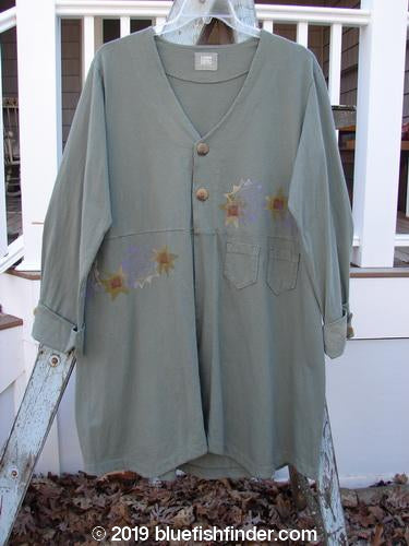 2000 Puzzle Jacket Star Eucalyptus Size 1: Long-sleeved shirt with star design. Deep V neckline, cuffed sleeves, and front accent pockets. Organic cotton.