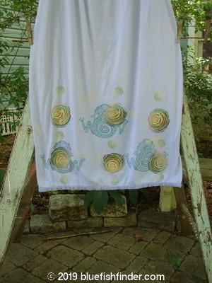 Image alt text: Barclay Little Lace Trim Skirt with frog and rose theme paint, featuring a white towel on a clothesline and a stone floor with a stick.