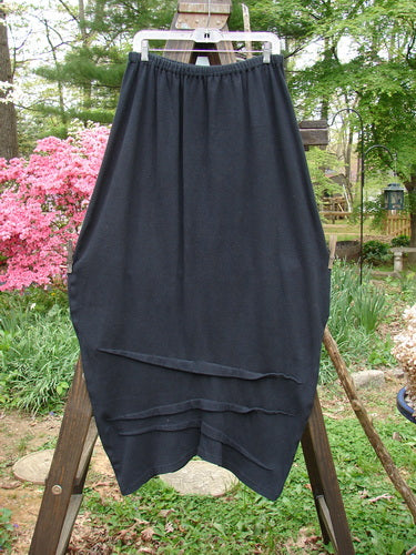 2000 Thermal Awen Skirt on wooden easel, featuring full elastic waistband, generous bell shape, and textured diagonal hemline. Size 2.