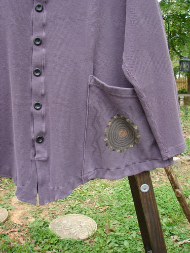 2000 Thermal Moonlight Cardigan Jacket Pinwheel Eggplant Size 2: A purple shirt with a pocket on it, featuring a rounded hemline and oversized front pocket.