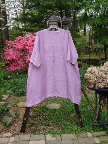 Barclay Linen Double Tie Back Jacket Garden Side Lilac Size 2: A purple dress with a huge A-line sweep, exterior stitchery, and front drop flop pockets.
