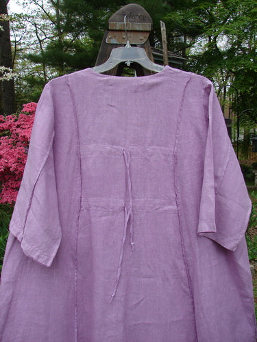 A Barclay Linen Double Tie Back Jacket in Lilac, featuring a deep V neckline, A-line sweep, and front drop flop pockets. Painted with a highly detailed garden theme. Bust 56, Waist 60, Hips 66, Front Back Length 40, Side 46.